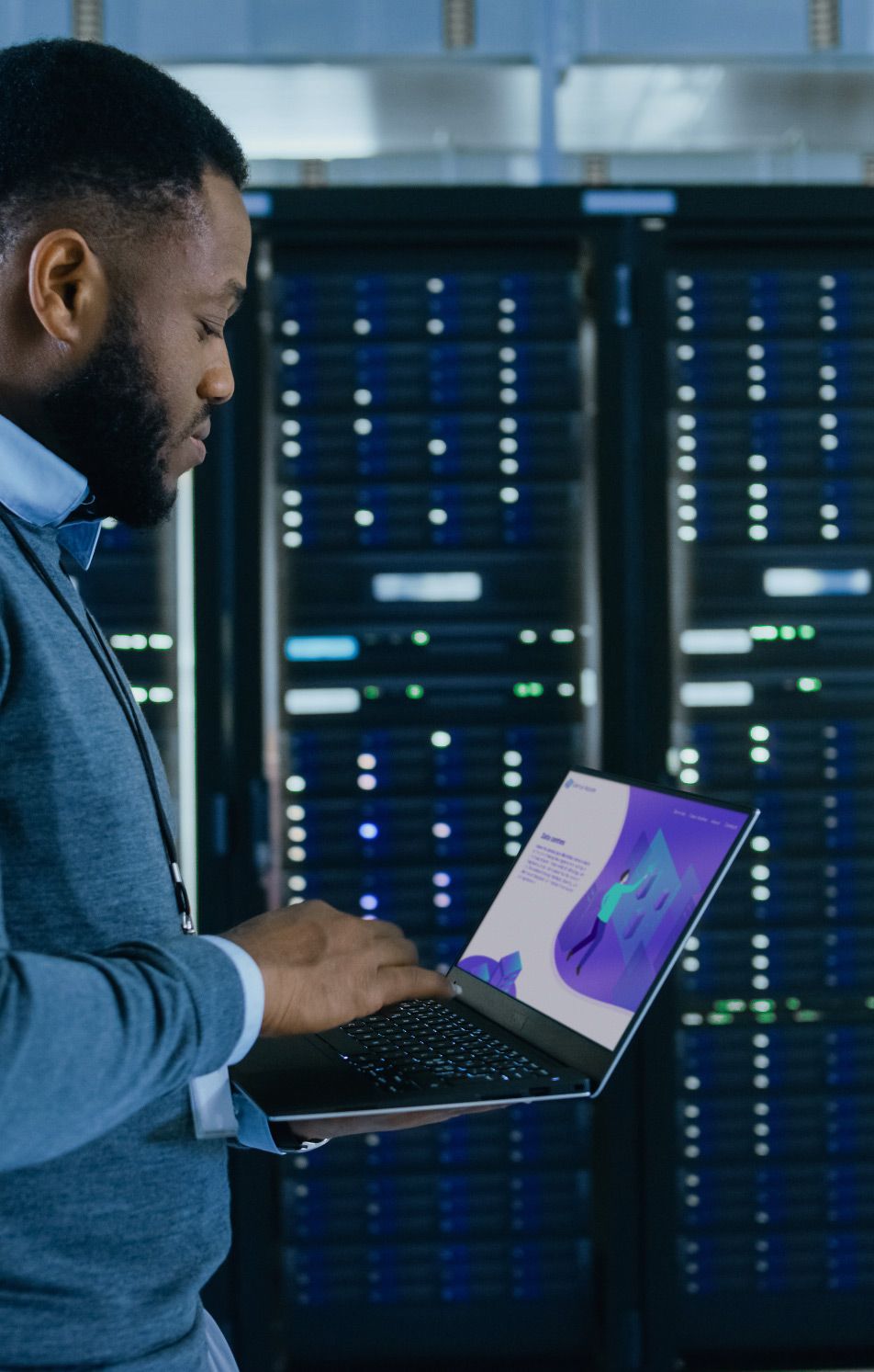 Man walking through data centre holding a laptop looking at a cloud storage website
